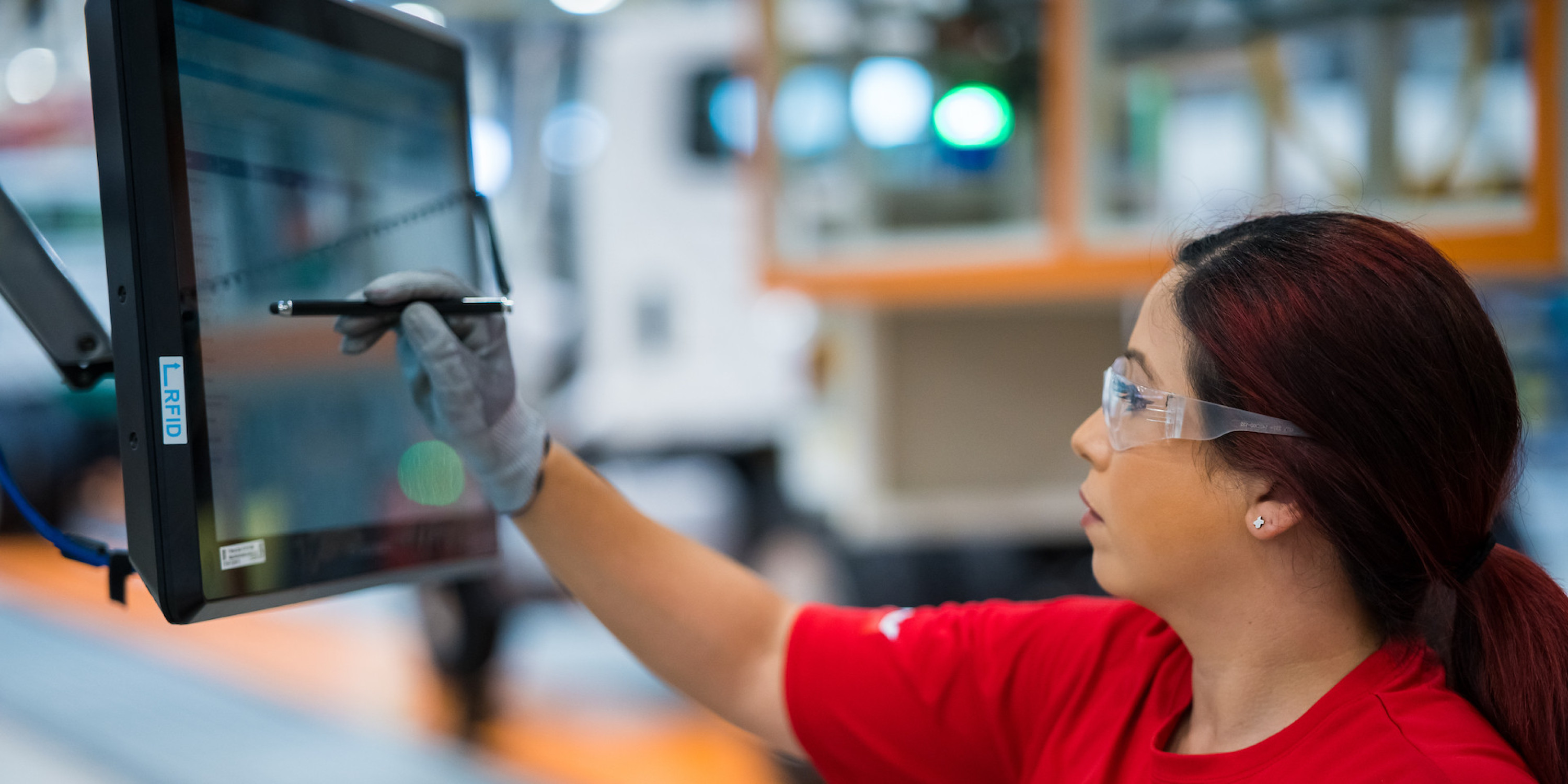 Woman working in manufacturing facility on digital screen