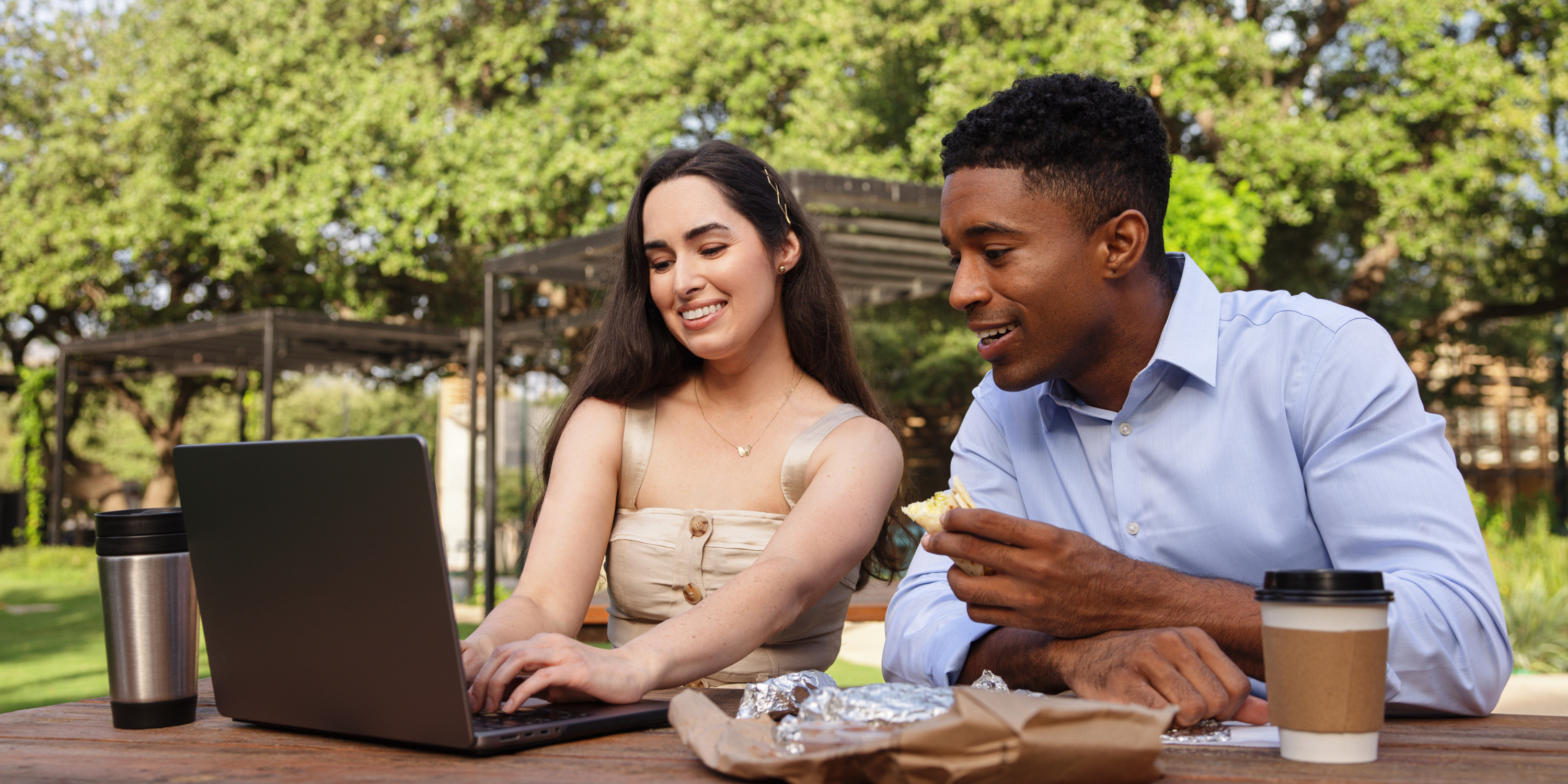 Man and woman at a park looking at a computer screen