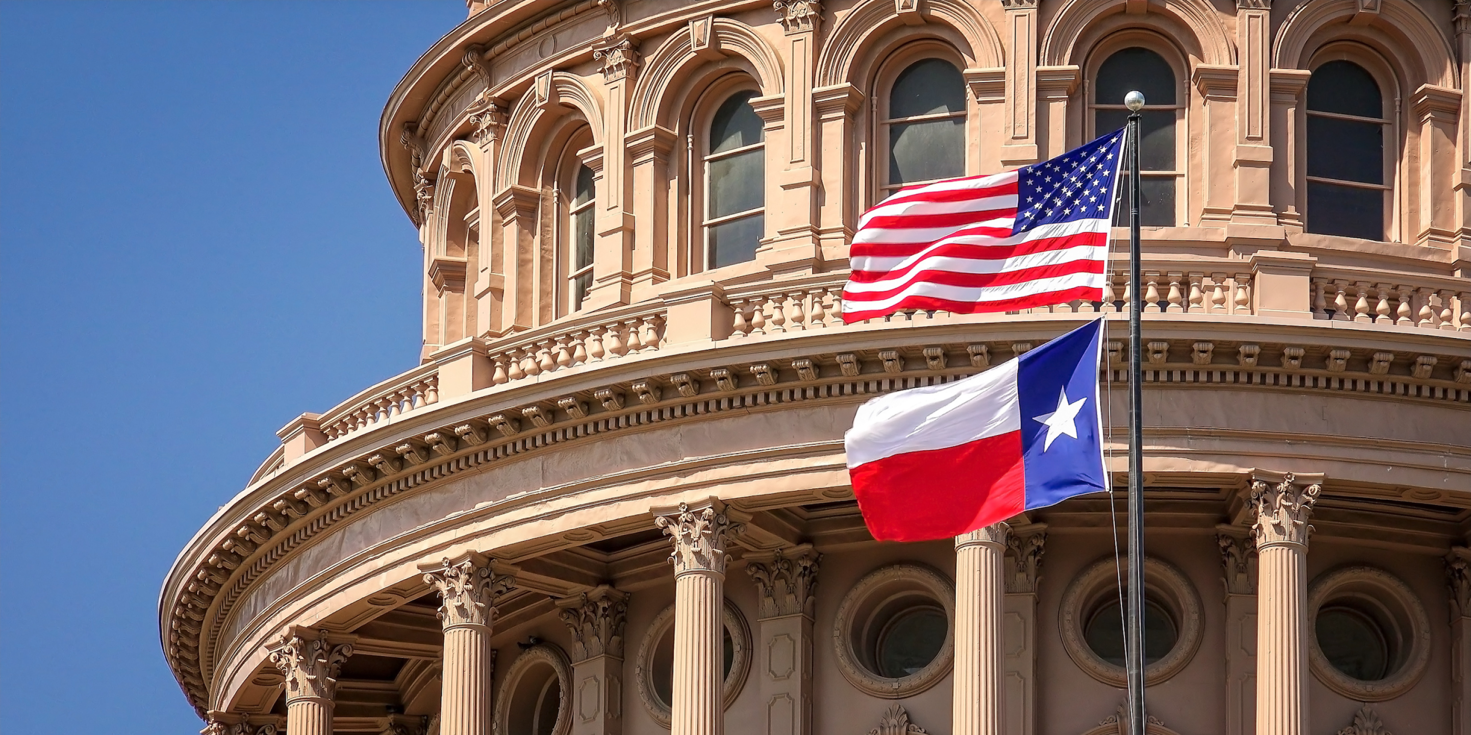 building with texas and us flags